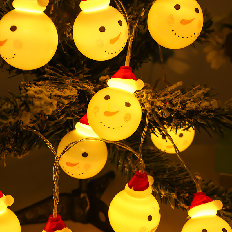 The Christmas snowman smiles with the led lights of the Christmas decorated light room.