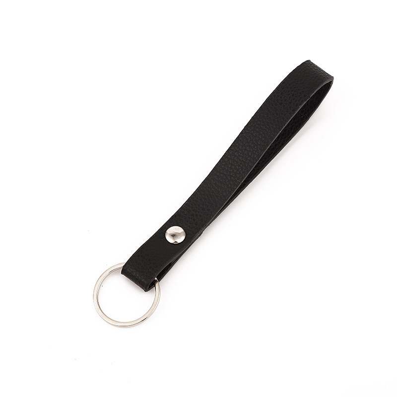 A gift car key button, a leash ring, a black twirl-ed leather key.