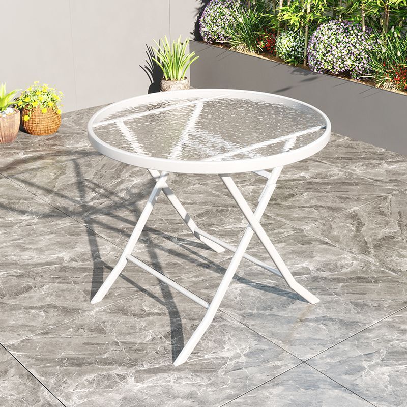 Outside steel glass table, white folding round table, two chairs on the table and tea table.