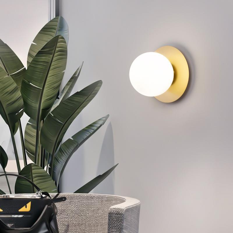 A very simple, round glass corridor walllight at the end of the stairs.