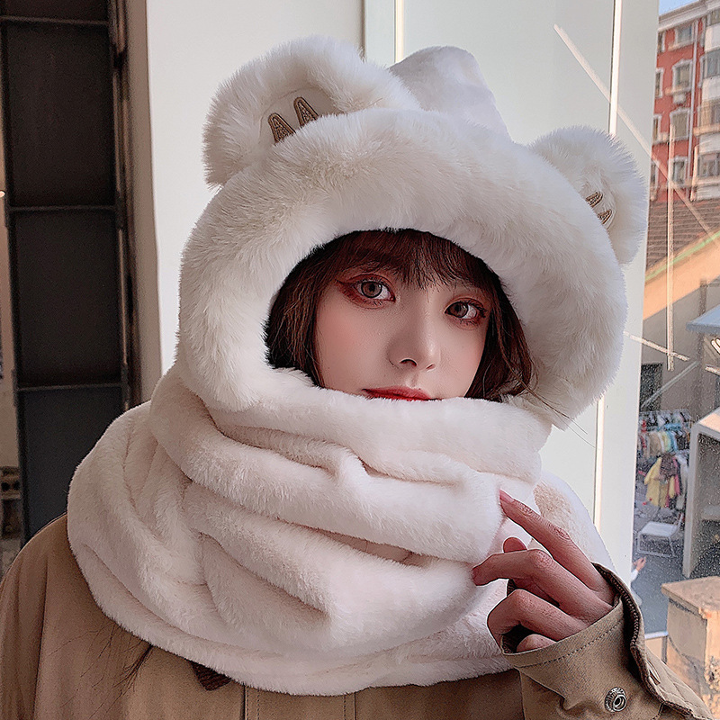 A bear hat girl with three pairs of warm gloves with a thick scarf for the autumn winter.