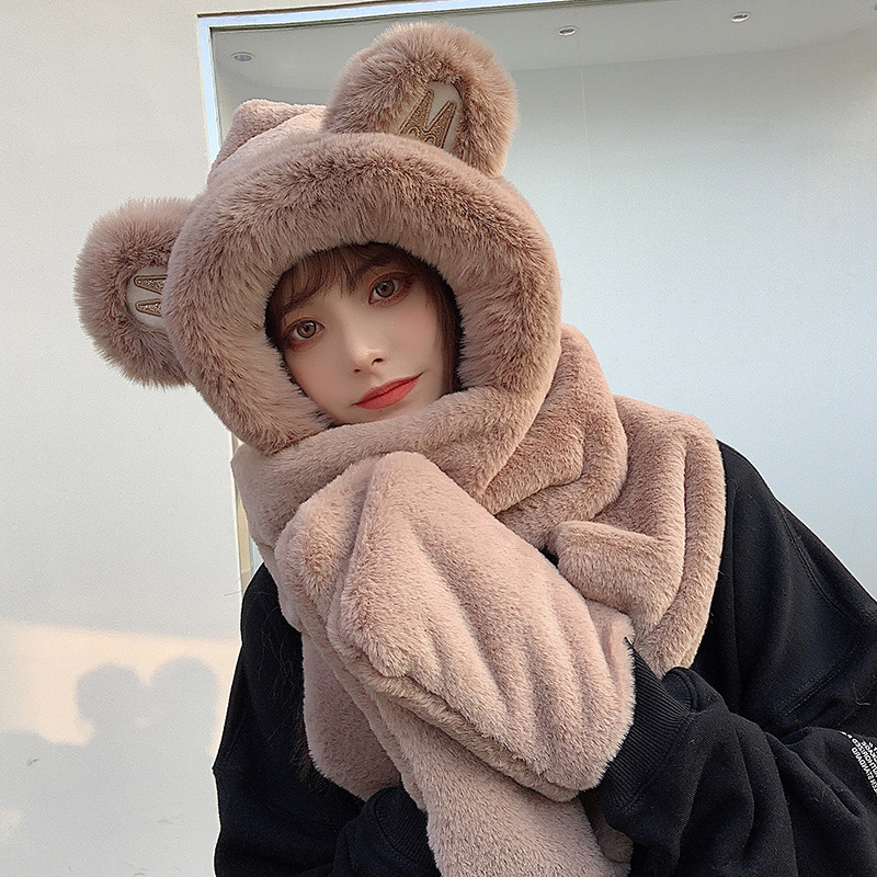 A bear hat girl with three pairs of warm gloves with a thick scarf for the autumn winter.