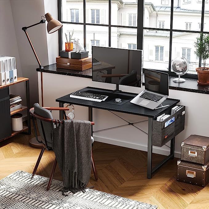 A solid home desk desk with bags and headphones.