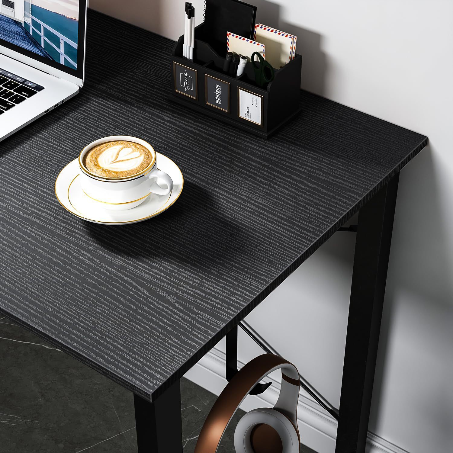 A solid home desk desk with bags and headphones.