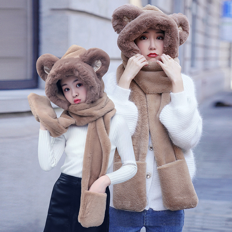 A bear hat girl with three pairs of warm gloves with a thick scarf for the autumn winter.