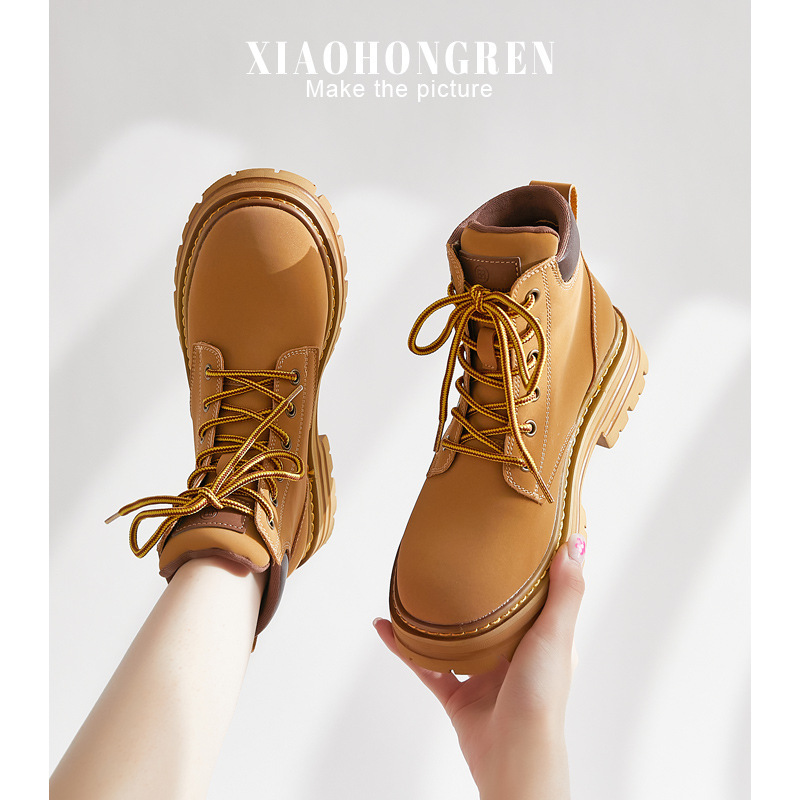 Cô bé tóc đỏ cho Martin Boots 2024 với đôi giày ngắn cho xe buýt.